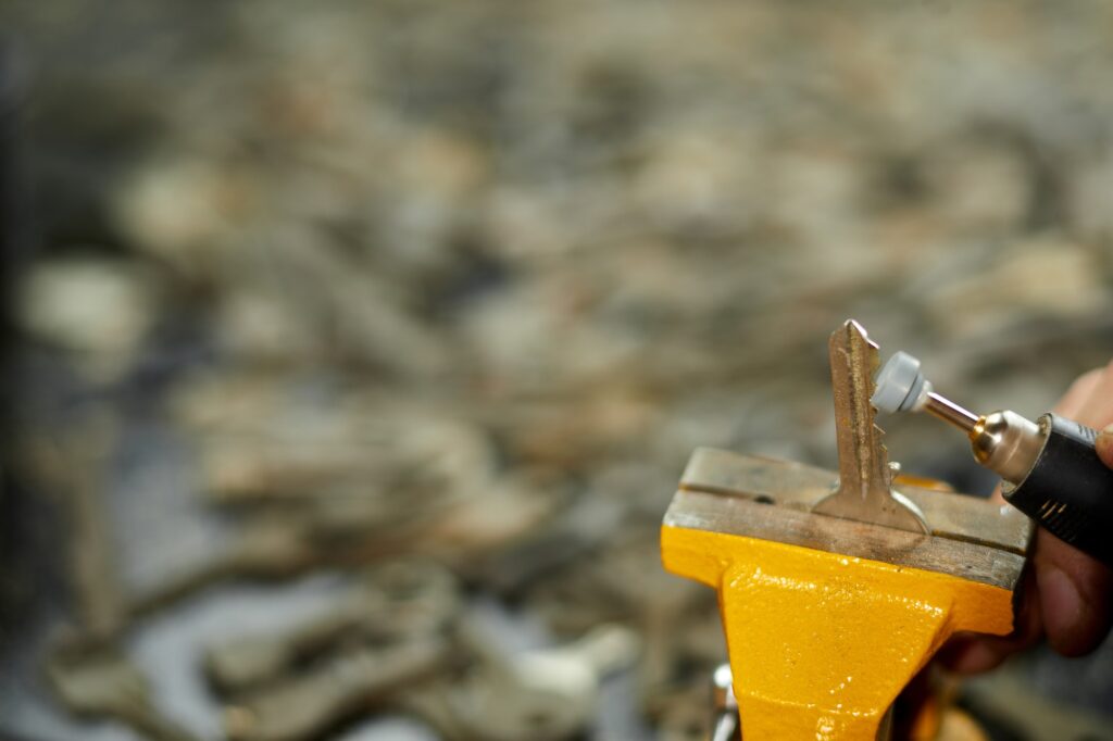 Locksmith in workshop makes new key, use grinding engraving machine